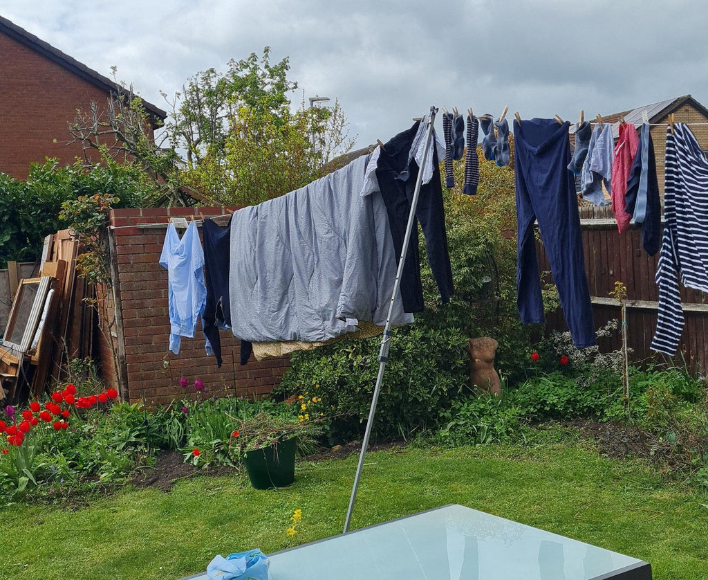 Clothes line prop holding up a loaded washing line in a garden