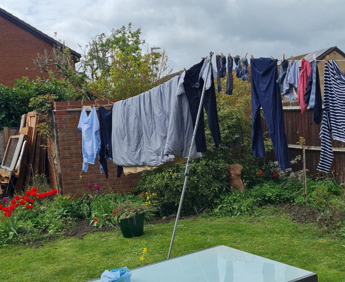 Clothes line prop holding up a loaded washing line in a garden