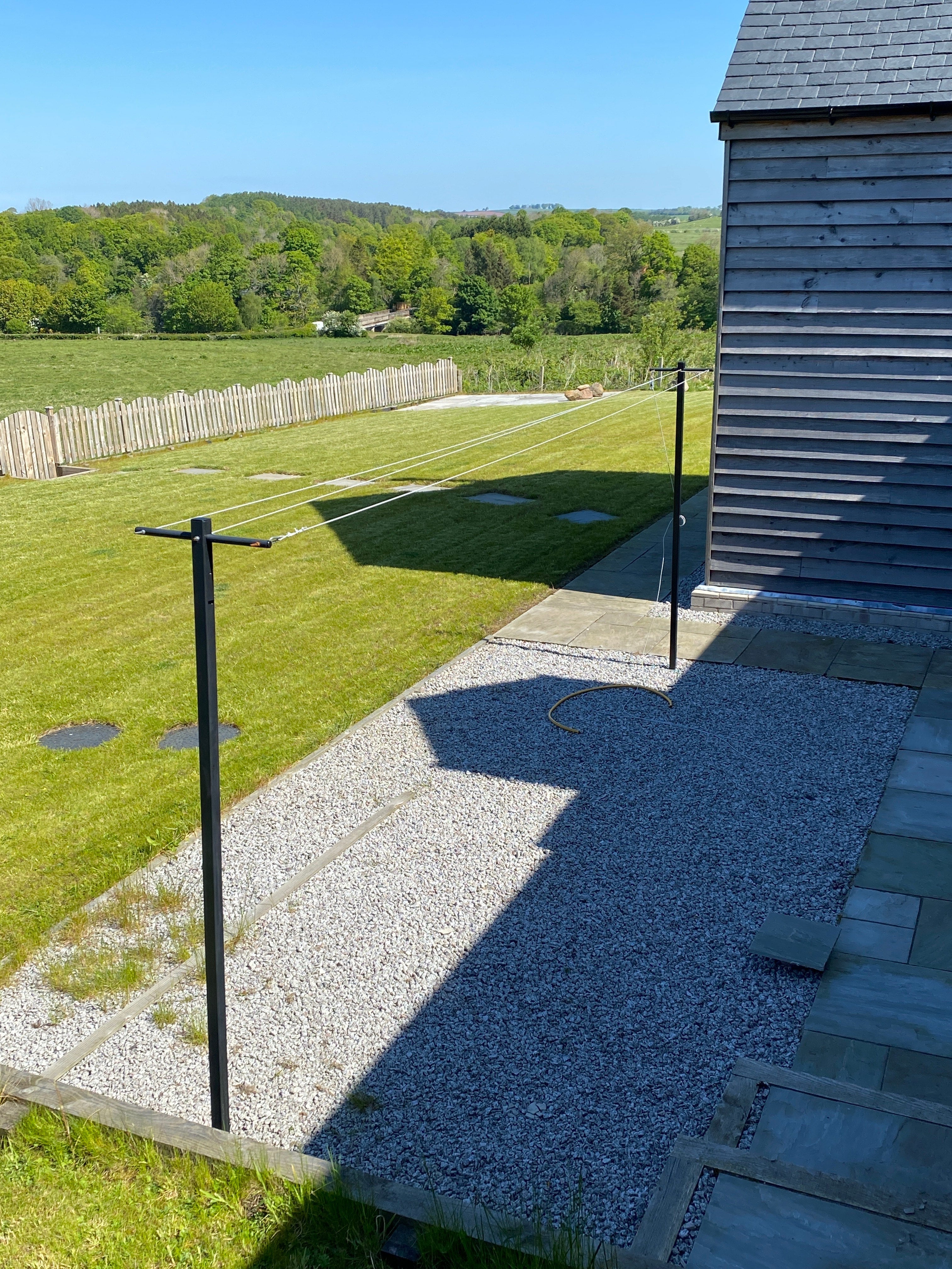 Multi-line clothesline post installed in a garden lawn